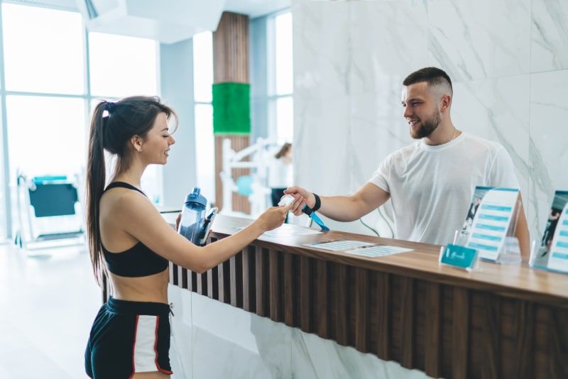 Two gym members talking while training together